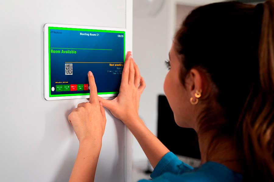 A woman booking a meeting room via a smart display.